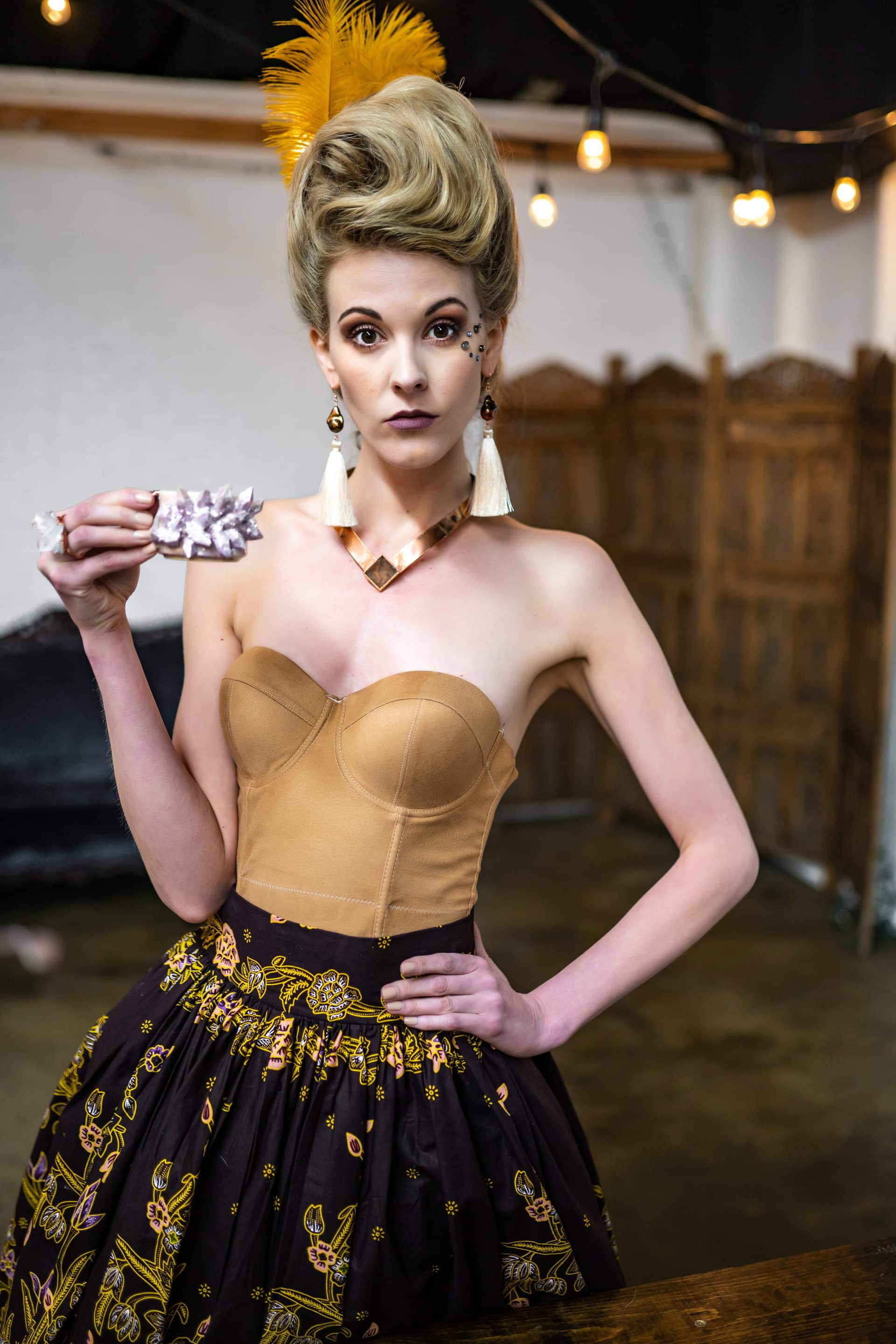 Model holding a teacup wearing Desert Daisy Jewelry from the Marie Collection