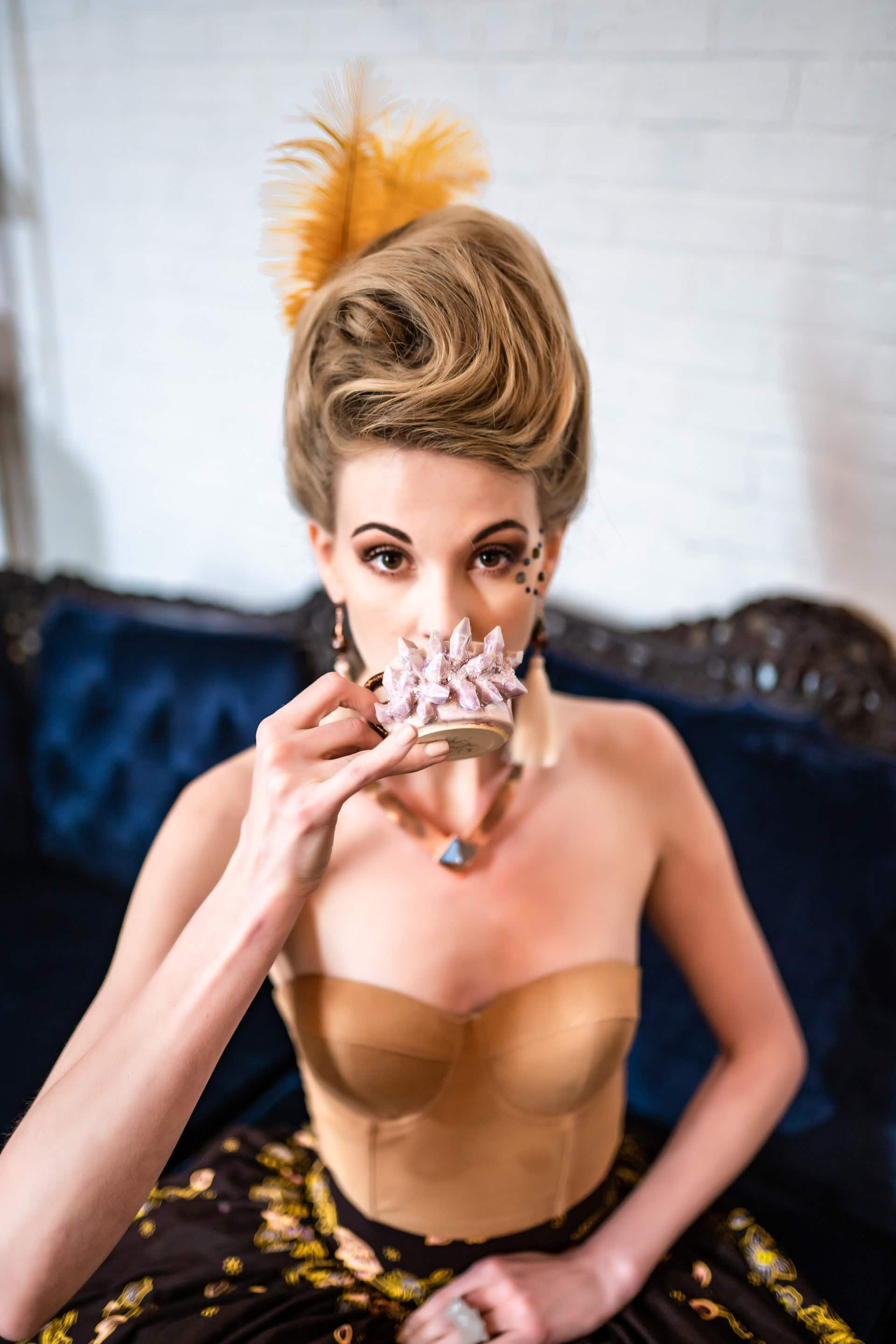 Model sipping tea wearing Desert Daisy Jewelry from the Marie Collection
